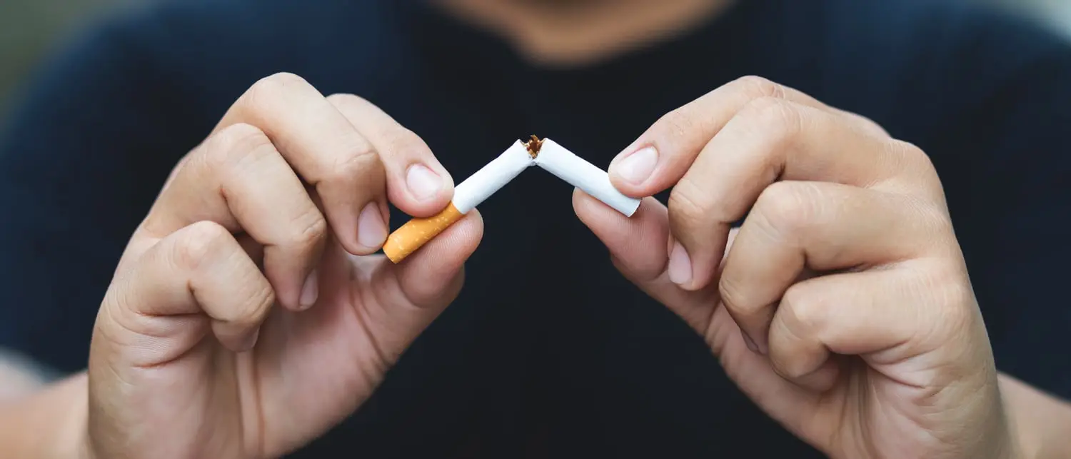 Des mains brisant une cigarette