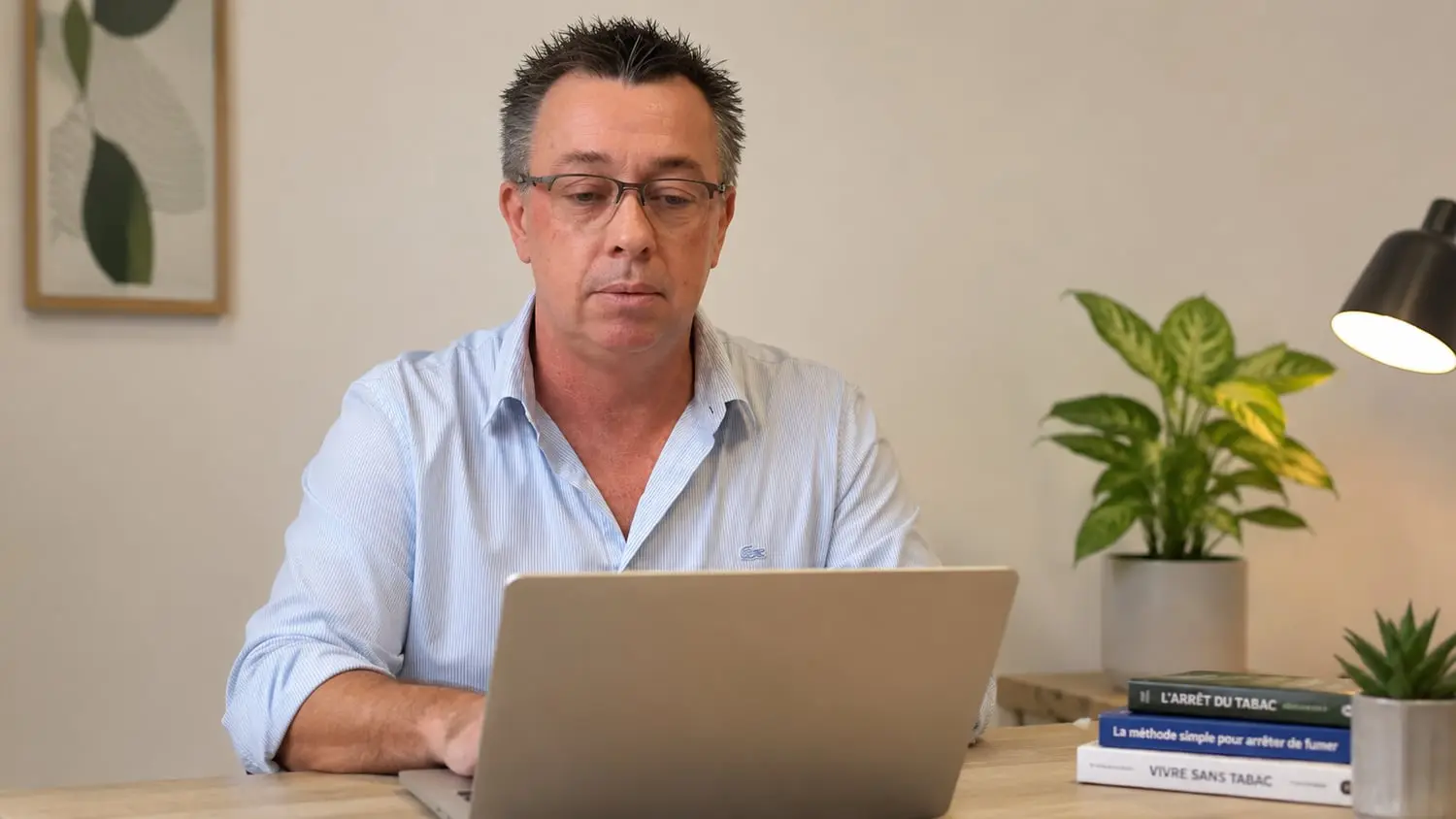Un homme suivant le programme en ligne sur son ordinateur portable