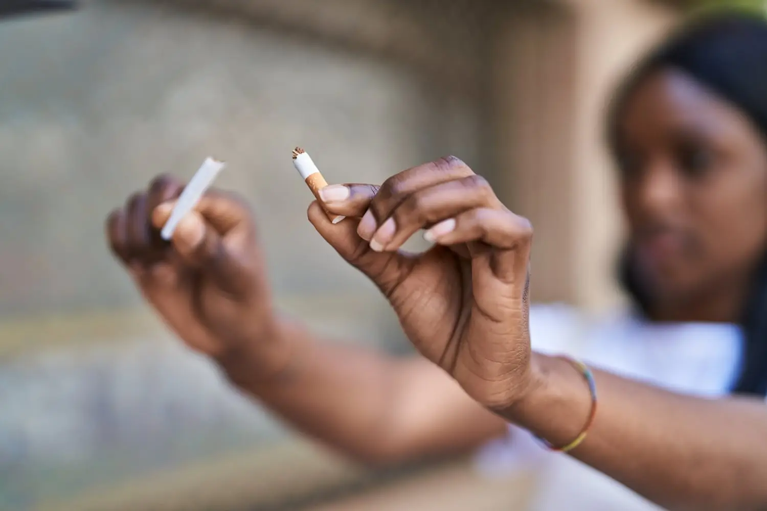 Deux mains cassant une cigarette