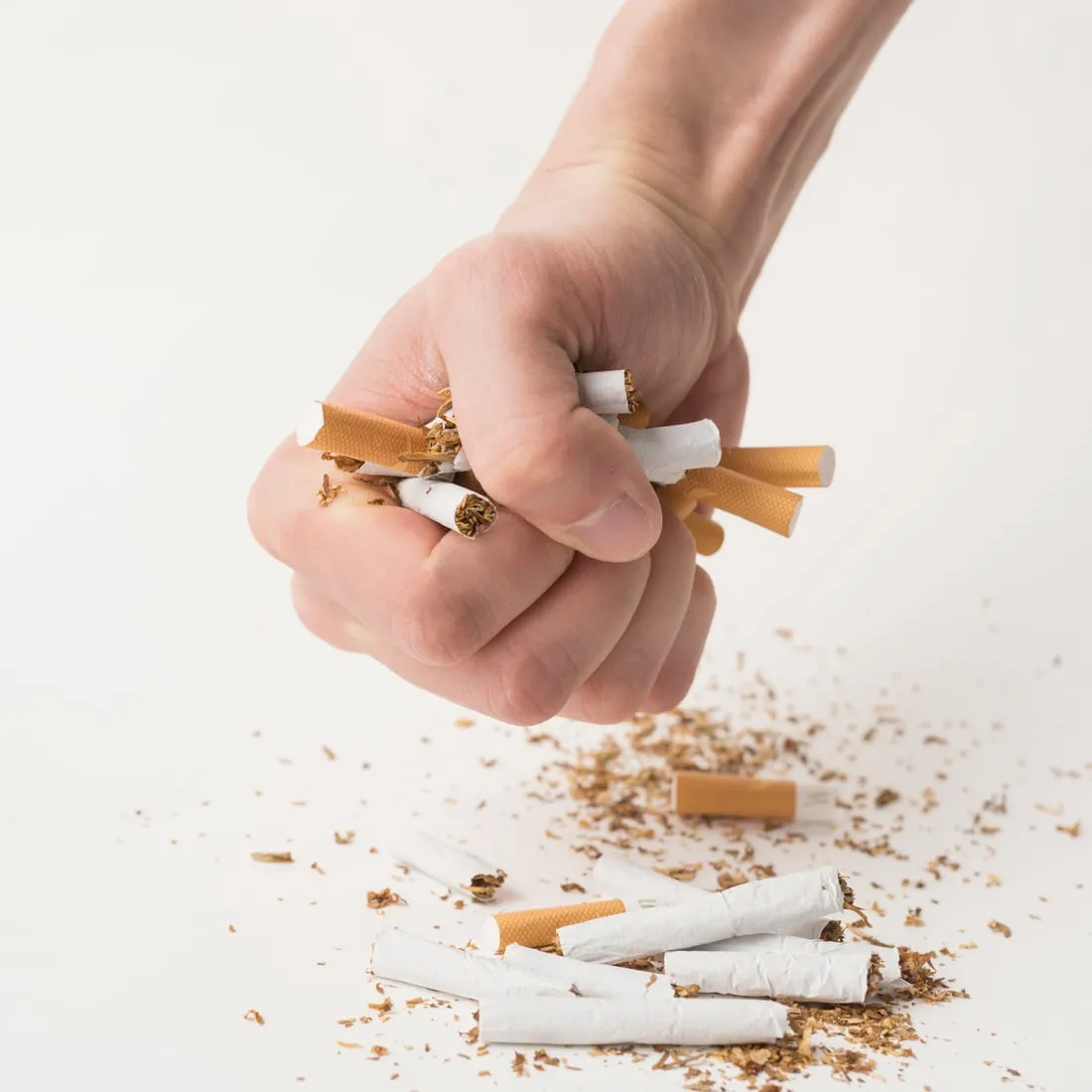 Une main écrasant des cigarettes