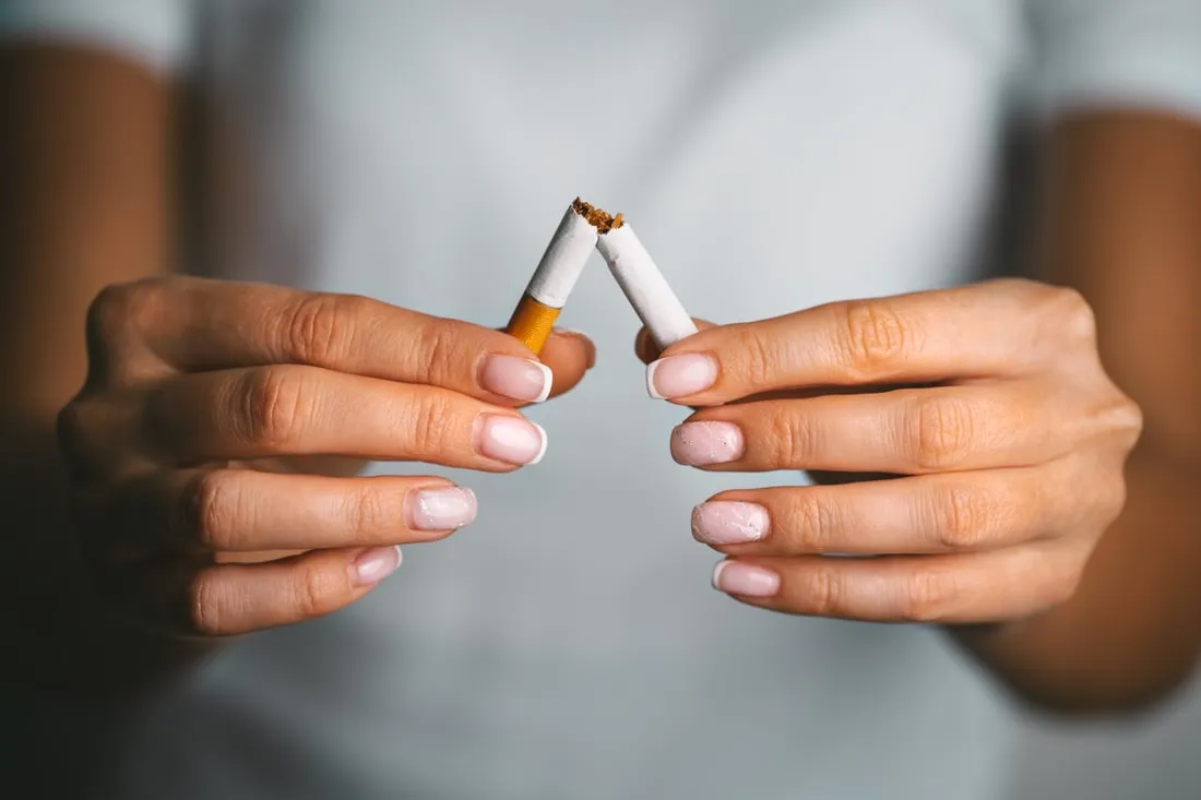 Deux mains cassant une cigarette en deux